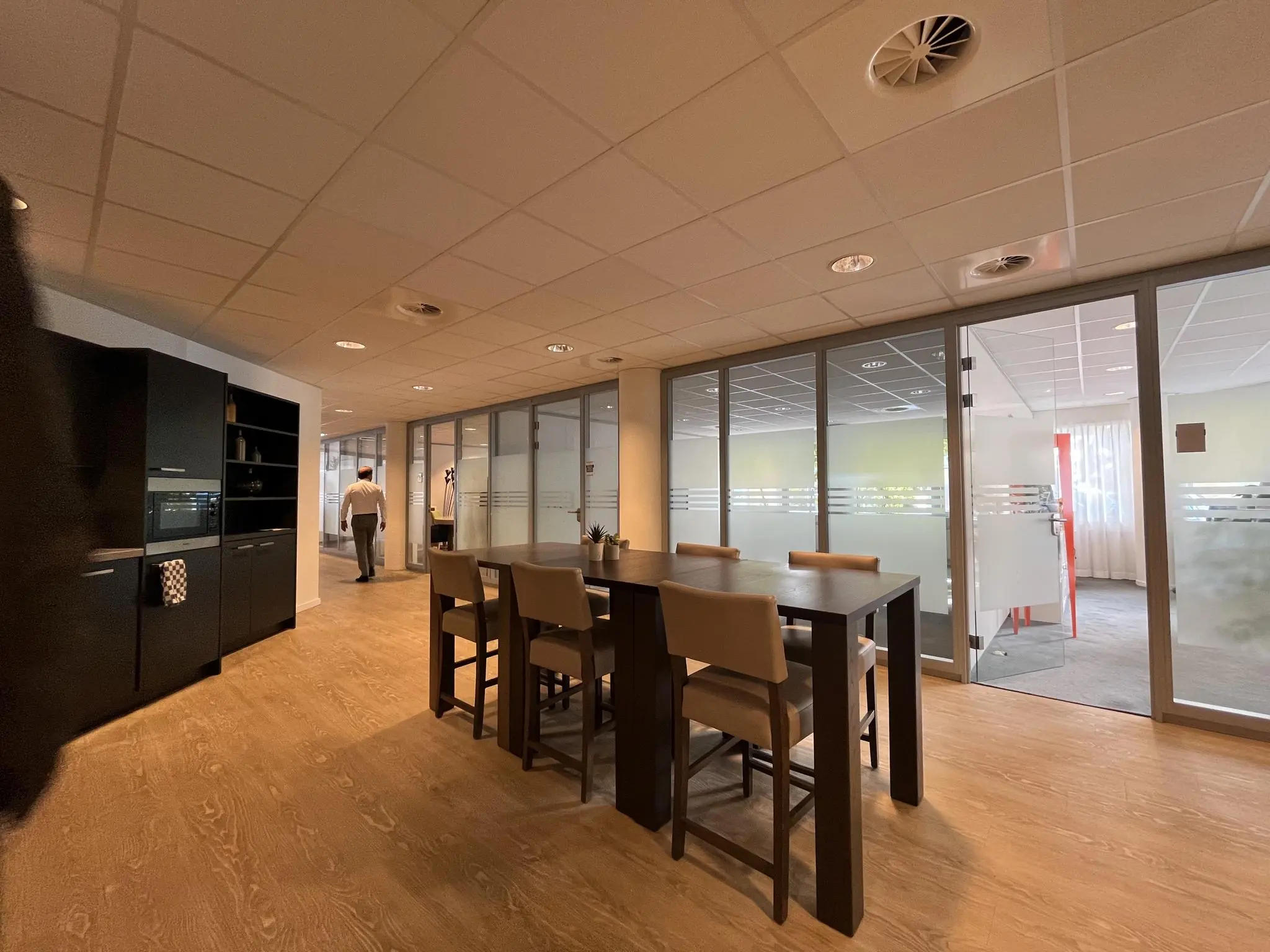 Moderne kantoorruimte aan de 1e Hogeweg met glazen vergaderruimtes, een zithoek en een kitchenette.